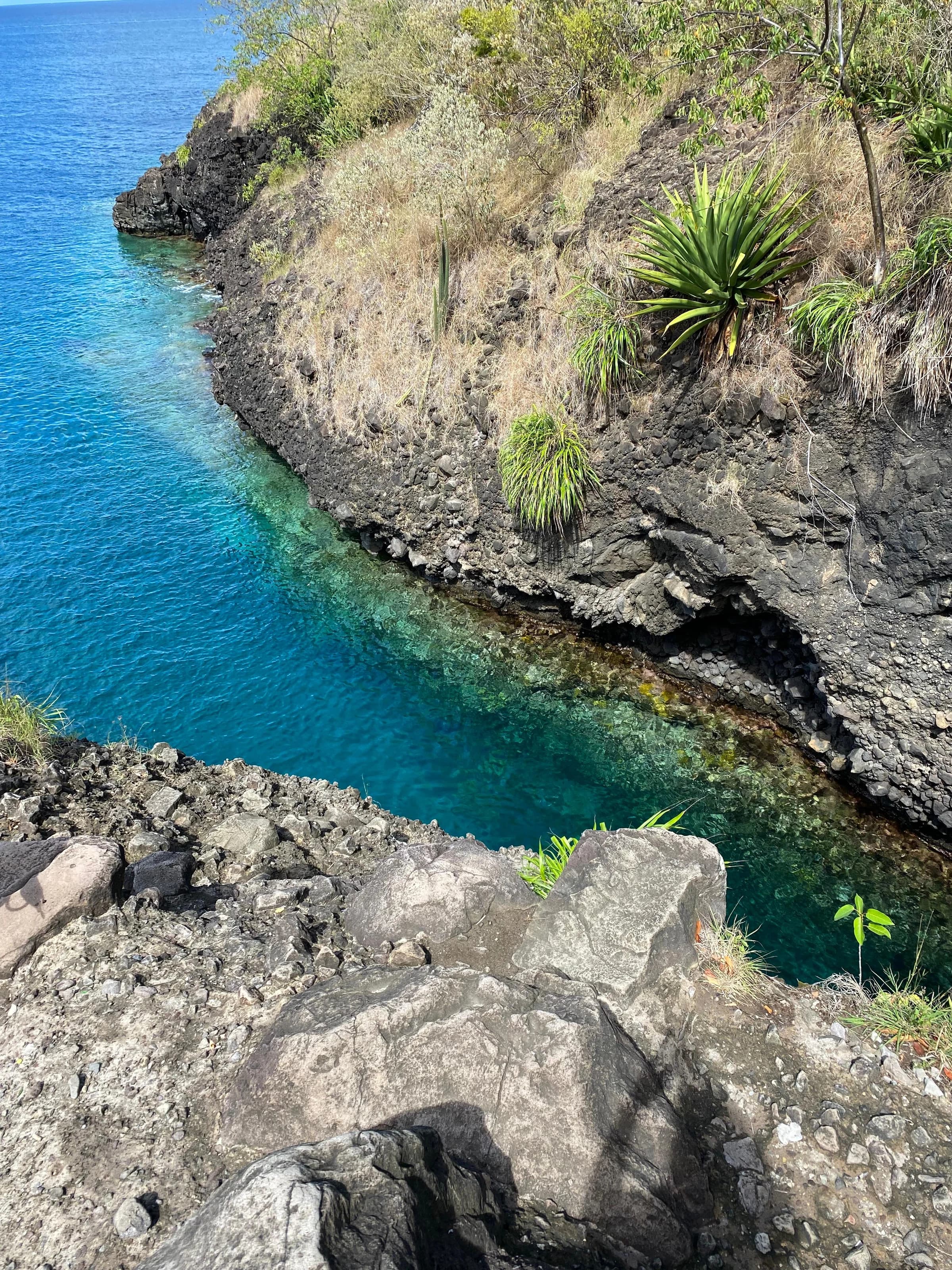 Crique volcanique avec eau turquoise et roches sombres